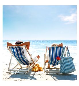 Couple On A Deck Chair Relaxing On The Beach - ID # 12999098